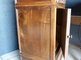 a wooden cabinet with a door open on a tiled floor