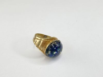 un gros plan d'une bague en or sertie d'une pierre de lapis-lazuli