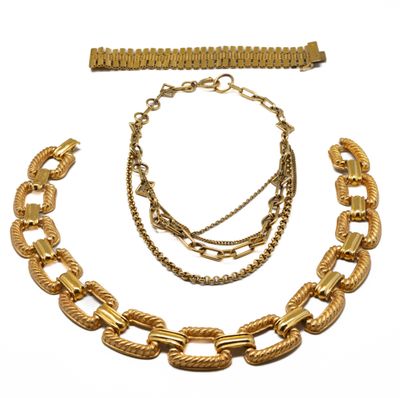 un gros plan d'un collier et d'un bracelet sur fond blanc