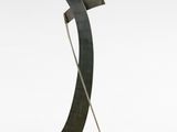 sculpture représentant un objet métallique courbé posé sur un socle en bois