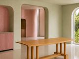 une table au milieu d'une pièce au plafond rose