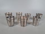 six silver cups are lined up in a row on a table