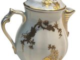 a white and gold tea pot with a gold lid
