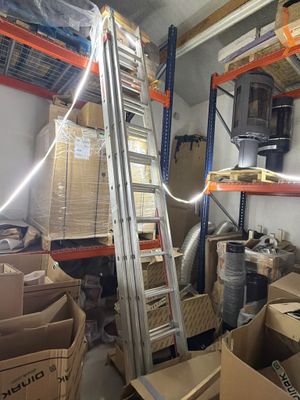 une pièce dans laquelle se trouvent une échelle, des cartons et d'autres objets