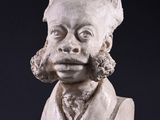statue of a bust of a man with a mohawk on a black surface