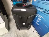 une valise noire posée par terre à côté d'un panneau bleu et blanc