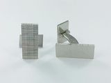 paire de boutons de manchette en argent sur fond blanc, avec un fond blanc