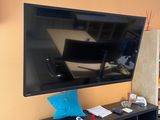 a flat screen tv mounted on the wall above a bookcase