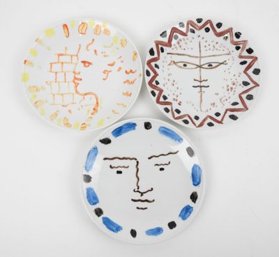 trois assiettes sur lesquelles sont peints des visages, sur un fond blanc
