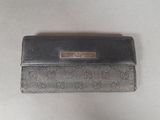 a close up of a black and silver purse on a white surface