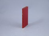 un livre rouge posé sur une surface blanche