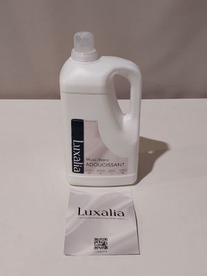 La bouteille de liquide est posée à côté de l'étiquette sur la table.
