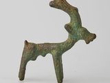 figurine en bronze représentant un cerf sur une surface blanche, avec un fond blanc