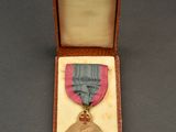 l'image d'une médaille dans une boîte entourée d'un ruban
