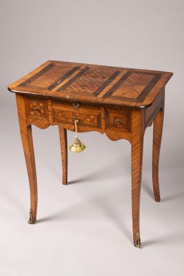une vieille table en bois sur laquelle est posée une clochette