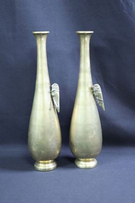 deux vases dorés ornés d'ailes sur fond bleu