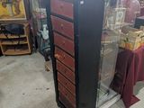 a tall black and red chest of drawers in a store