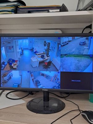 un écran posé sur un bureau, avec un clavier et une souris