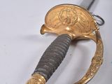 an image of a gold sword with a black handle on a white surface