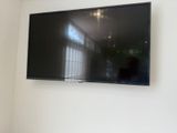 une télévision à écran plat fixée au mur dans un coin de la pièce