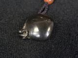 a metal object with a bead on it on a black surface