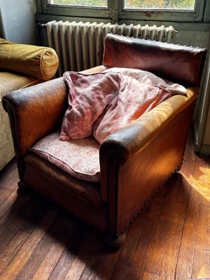 une chaise marron recouverte d'une couverture, placée devant un radiateur