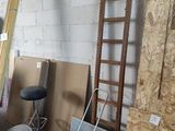a room with a ladder, a chair, a bucket, and other items in it