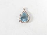 un gros plan d'un pendentif composé d'une topaze bleue et de diamants, sur fond blanc