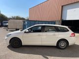 la voiture blanche est garée devant un bâtiment