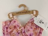 un gros plan sur un haut de soutien-gorge rose suspendu à un cintre