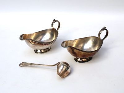 two silver plated dishes and spoons on a white surface