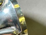 a close up of a silver ring with a fish on it