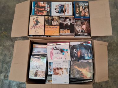 de nombreux DVD dans une boîte posée par terre