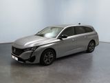 La voiture argentée est garée dans une pièce aux murs blancs.