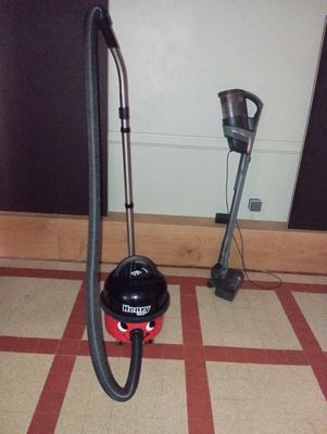 a black and red vacuum sitting on the floor next to a red and white checkered floor