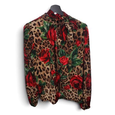 une chemise à imprimé léopard ornée de roses rouges, suspendue à un cintre