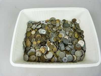 un bol blanc rempli de nombreuses pièces de monnaie posé sur une table