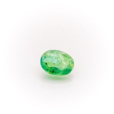 a close up of a green emerald stone on a white surface