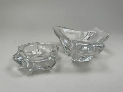 une paire de cendriers en verre transparent posés sur une surface blanche
