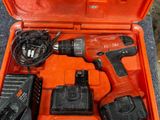 une boîte à outils orange contenant une perceuse et deux batteries