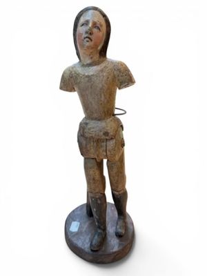 figurine en bois représentant un homme coiffé d'une capuche et les mains sur les hanches