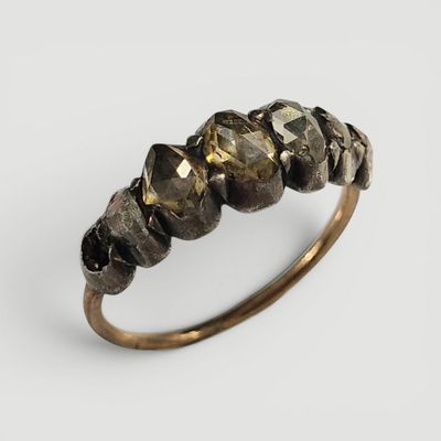 un gros plan d'une bague en or sertie de plusieurs pierres