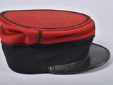 a red and black hat on a white surface