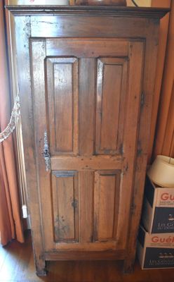 a wooden cabinet with a chain hanging from the top of it