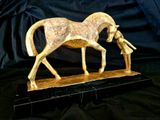 a statue of a horse with a man standing next to it