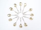 des cuillères en argent disposées en cercle sur une surface blanche