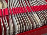 a lot of silver spoons and spoons in a red box