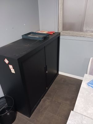 une armoire noire dans un coin d'une petite pièce