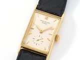 a close up of a watch on a black strap on a white surface