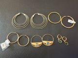 six pairs of gold hoop earrings and a pair of gold hoop earrings